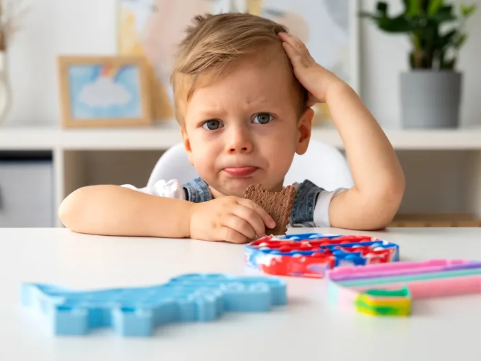 Young boy thinking through a puzzle at a table