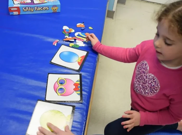 Child playing in a sensory bin with an occupational therapist