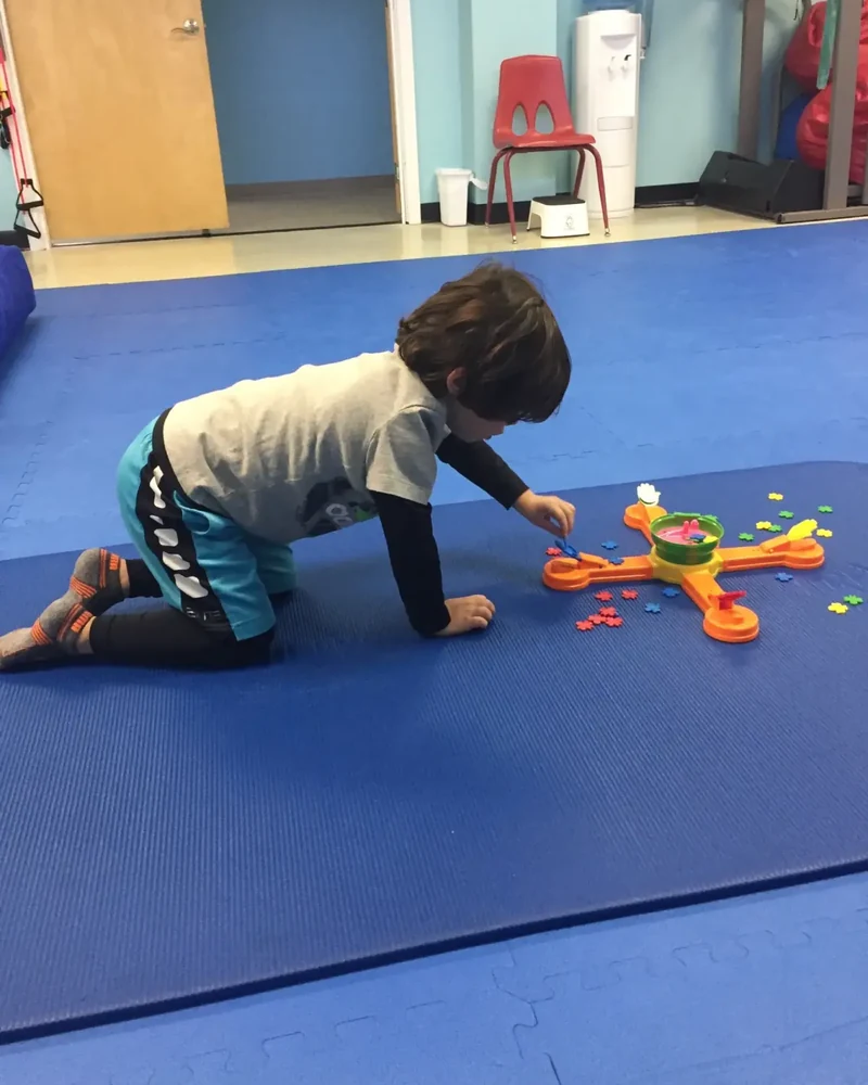 Child swinging and climbing during a sensory occupational therapy session