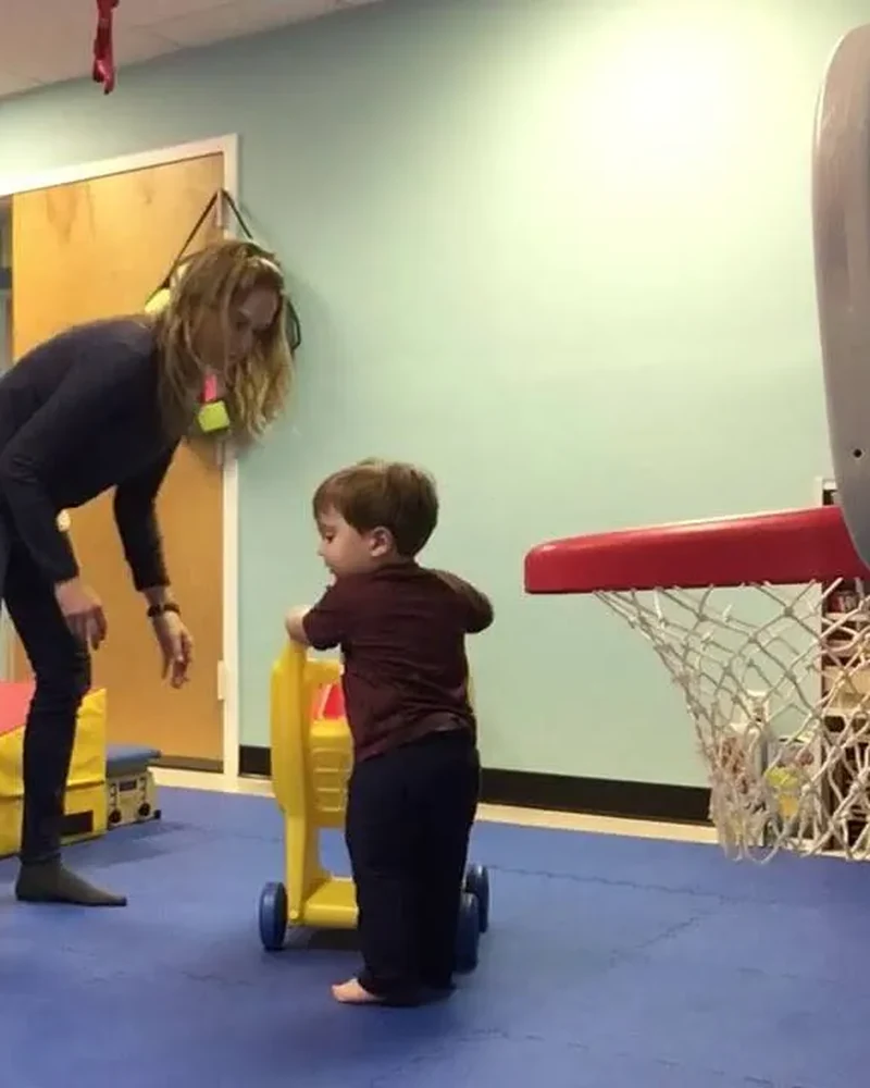 Therapist teaching a parent how to practise an exercise with their child at home