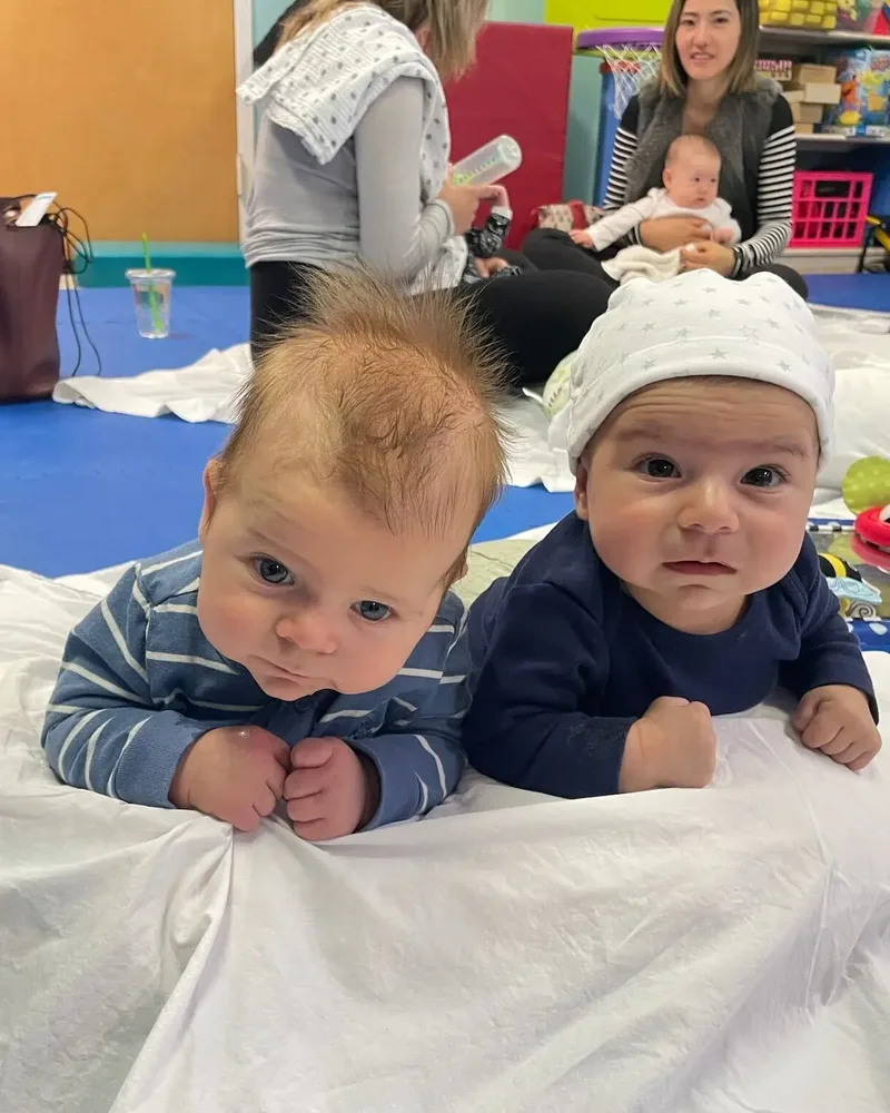 Two babies doing tummy time side by side during a group class