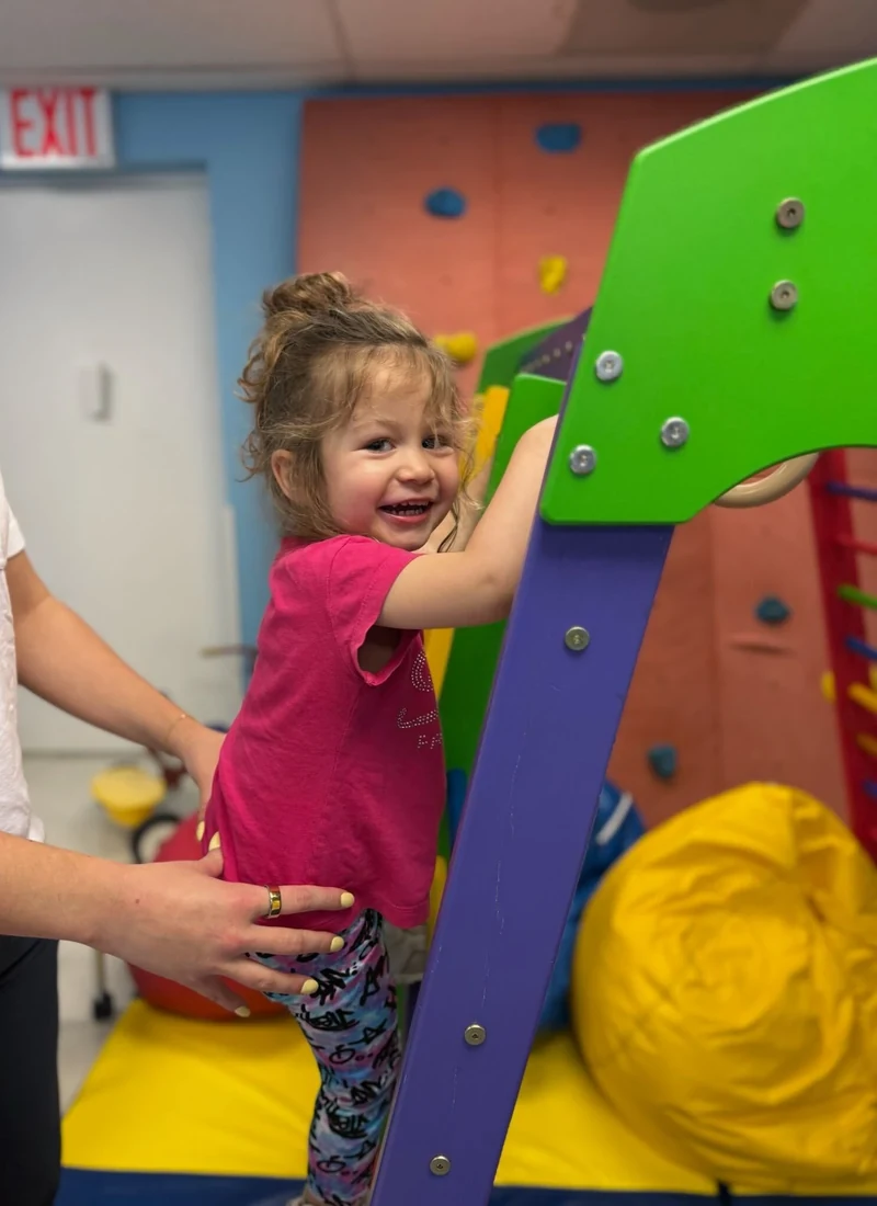 Young child mid-stride during a pediatric physical therapy session